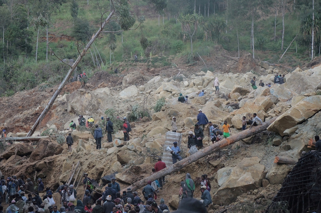 Nhân viên cứu trợ và người dân tại hiện trường vụ lở đất ở tỉnh Enga - Papua New Guinea hôm 26-5 Ảnh: REUTERS