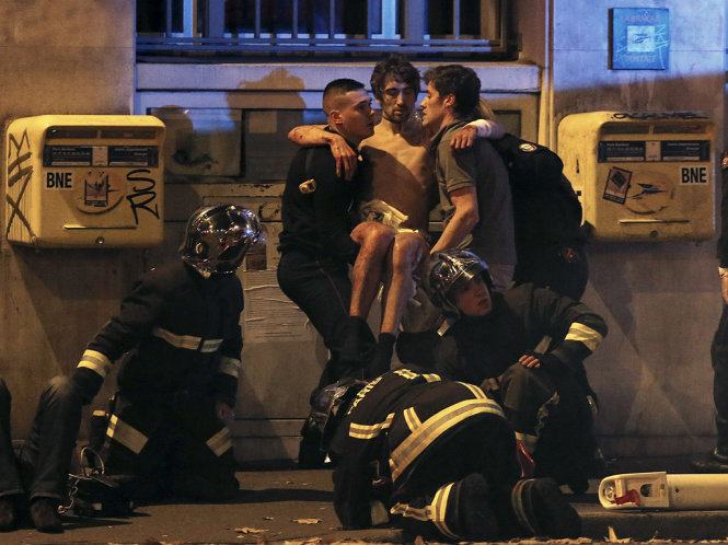 Cảnh sát Pháp đưa một nạn nhân bị thương khỏi nhà hát Bataclan, nơi bị bọn khủng bố tấn công đêm 13-11 - Ảnh: Reuters