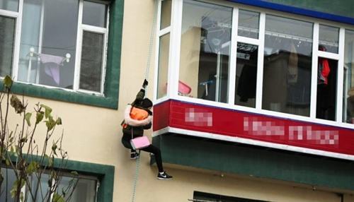 Lee Yumi trèo dây thừng từ căn hộ tầng 4 một tòa nhà ở Diên Cát, nơi cô bị nhốt suốt 5 năm. Ảnh: CNN.