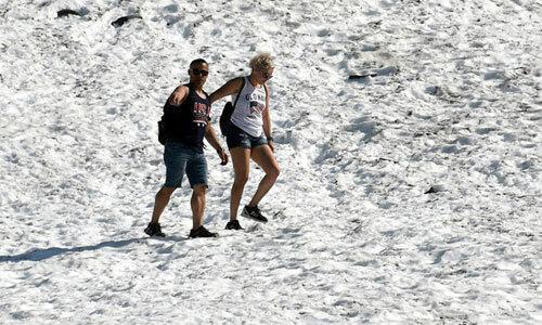 Người dân mặc quần áo cộc đi bộ ở Alaska giữa trời nắng nóng hôm 4/7. Ảnh: NPR.