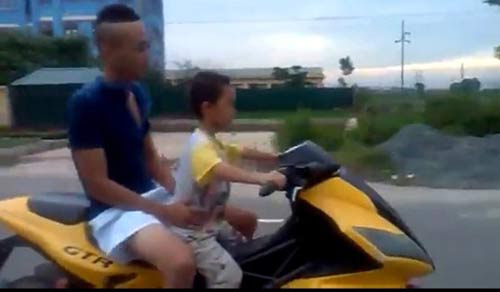 Bé trai lái xe phân khối lớn trên đường