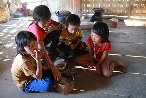 Dậu (thứ hai từ trái sang) đang chăm sóc bữa trưa cho các em. 