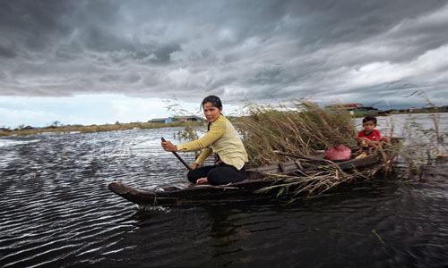 Hai mẹ con chèo thuyền trên Biển Hồ. Ảnh: NYT.