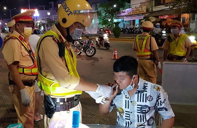 CSGT hướng dẫn tài xế thổi bong bóng, sau đó chuyển sang máy đo nồng độ cồn /// Ảnh: Trần Thanh Phong