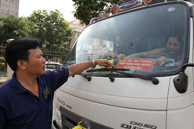 Tài xế Nguyễn Thành Vũ dán bảng chữ “Lái xe an toàn” trên kính xe vì sợ bị phạt - Ảnh: V.TR.