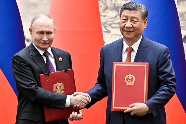 Chủ tịch Trung Quốc Tập Cận Bình và Tổng thống Nga Vladimir Putin trao đổi văn kiện tại cuộc gặp  ở thủ đô Bắc Kinh hôm 16-5 Ảnh: REUTERS