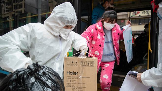 Một bệnh nhân COVID-19 nữ hồi phục được đưa đi cách ly 14 ngày ở Vũ Hán /// AFP