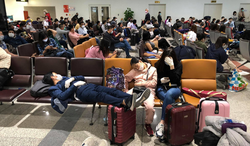 Cả trăm người về từ các nước Châu Âu sáng 18/3 đang chờ ở nhà ga T2 để về khu cách ly tập trung.Ảnh: Giang Huy