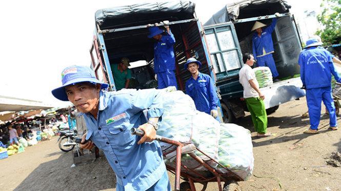 Vận chuyển hàng hóa tại chợ đầu mối nông sản Hóc Môn, TP.HCM trưa 22-12. Người kinh doanh kêu trời vì doanh nghiệp vận tải chưa giảm giá cước - Ảnh: Quang Định