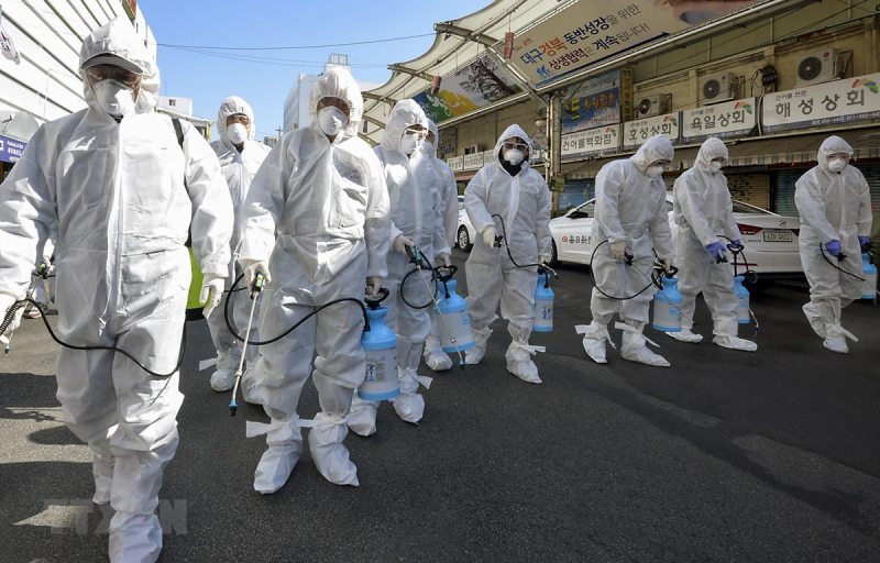 Nhân viên y tế phun thuốc khử trùng một khu chợ ở thành phố Daegu, Hàn Quốc ngày 23/2. (Ảnh: THX/TTXVN)