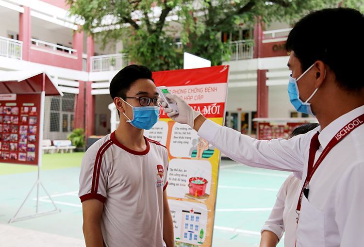 Đo thân nhiệt học sinh trước khi vào lớp tại trường iSchool Nha Trang, ngày 2/3. Ảnh: Xuân Ngọc.