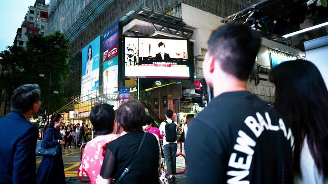 Người dân Hồng Kông theo dõi bài phát biểu của Đặc khu trưởng Lâm Trịnh Nguyệt Nga /// Reuters