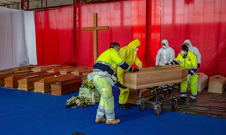 Nhân viên của&nbsp;Cơ quan Bảo vệ dân sự Italy di chuyển quan tài người chết vì Covid-19 ở thành phố Bergamo hôm 31/3. Ảnh: Bloomberg News.&nbsp;