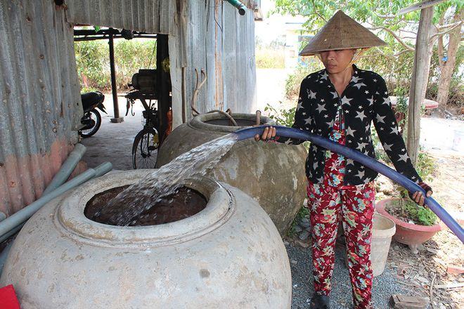 Người dân H.An Minh, Kiên Giang kéo ống bơm nước mua từ sà lan 