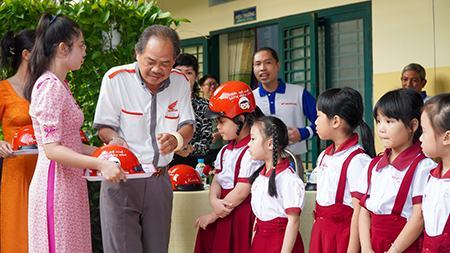 Tặng mũ bảo hiểm và hướng dẫn học sinh lớp 1 tham gia giao thông an toàn