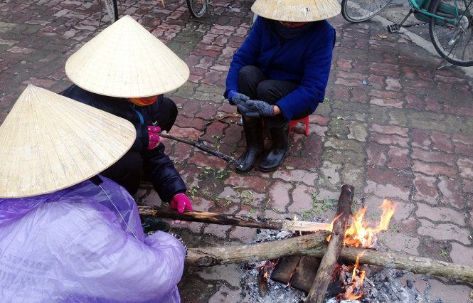 Lao động tự do ở TP Vinh đốt lửa chống cái rét cắt da, cắt thịt - Ảnh: Doãn Hòa