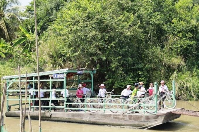 Những em học sinh phải đi phà qua bên kia sông để đi học.