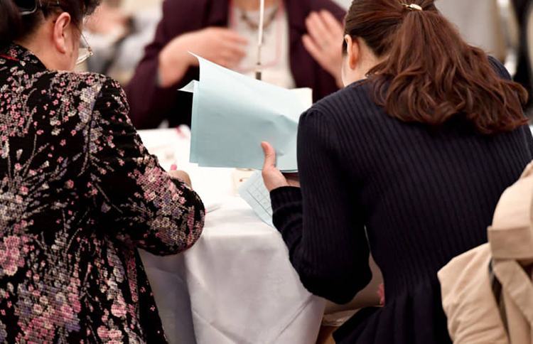 Một bà mẹ (áo hoa, bên trái) đưa con gái (phải) đến dự tiệc mai mối ở Tokyo. Ảnh: AFP.