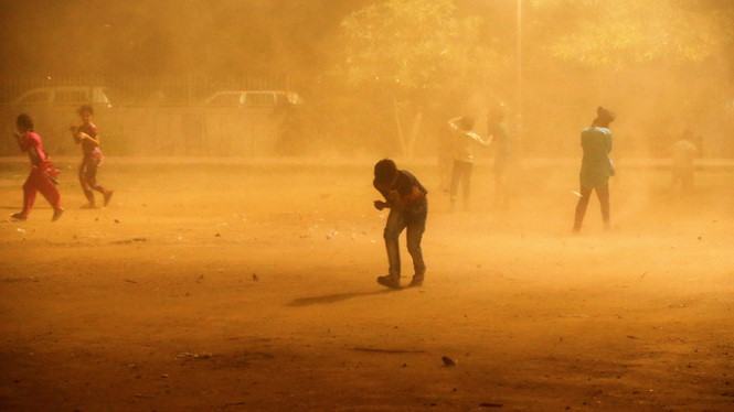 Trẻ con chạy tán loạn tìm chỗ trú khi bão bụi bất ngờ ập đến /// Reuters