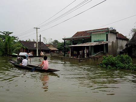 Các em nhỏ phải đi lại bằng thuyền trên dòng nước lũ