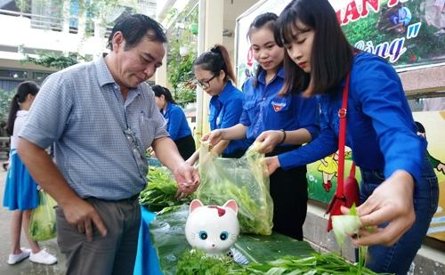 Giáo viên bỏ tiền vào hủ heo đất khi mua rau. Ảnh: Thạch Thảo.