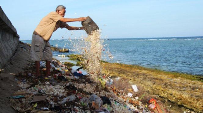 Một người dân vô tư đổ rác thải xuống bãi kè đoạn qua xã An Hải, huyện Lý Sơn - Ảnh: Phan Thành