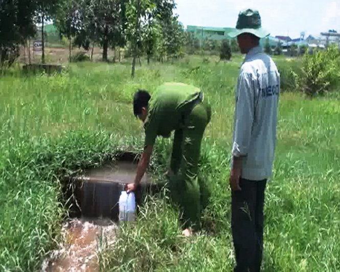 Cảnh sát môi trường lấy mẫu thử nước xả thải ra môi trường - Ảnh: Ngọc Hậu