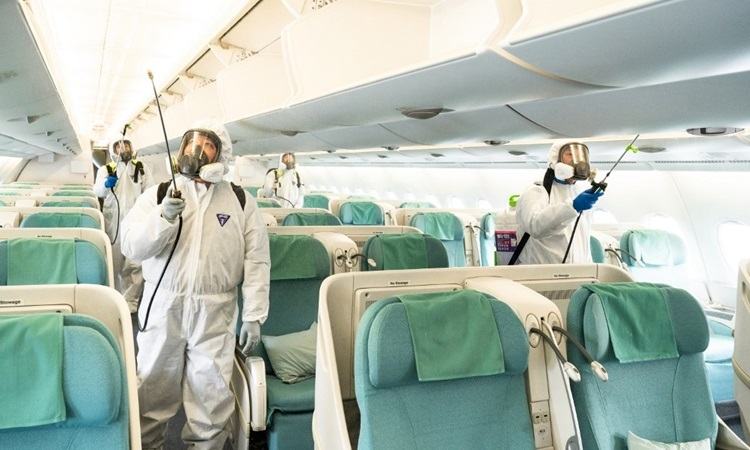 Công nhân khử trùng chuyến bay của Korean Air tại sân bay quốc tế Incheon hôm 4/3. Ảnh: AFP.
