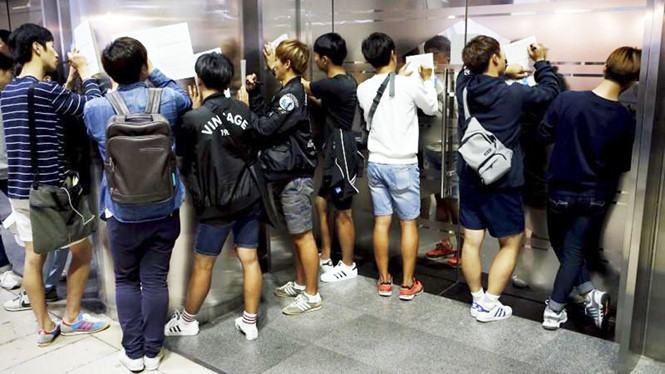 Thanh niên Hàn Quốc điền mẫu đơn đăng ký thi công chức ///  Ảnh: Reuters