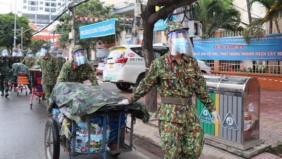 Lực lượng vũ trang Quân khu 7 vận chuyển nhu yếu phẩm giúp người dân những ngày thành phố giãn cách. Ảnh: THẾ ANH