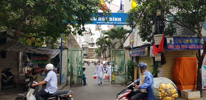 Cán bộ y tế đến lấy mẫu từ 43 cư dân Chung cư Hòa Bình về xét nghiệm trong sáng 14.3. /// Ảnh: Duy Tính