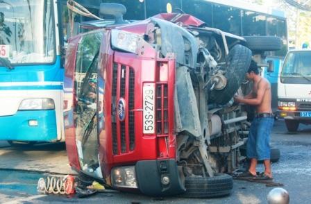 TPHCM: Tông giải phân cách, ô tô 16 chỗ lật nhào trên phố