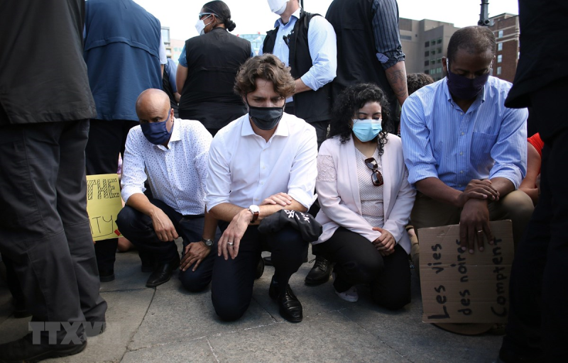 Thủ tướng Canada Justin Trudeau (thứ 2, trái, ngồi) tham gia tuần hành chống phân biệt chủng tộc trước tòa nhà Quốc hội ở thủ đô Ottawa ngày 5/6/2020. (Ảnh: AFP/TTXVN)