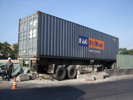 Xe container nằm vắt ngang rào chắn công trình