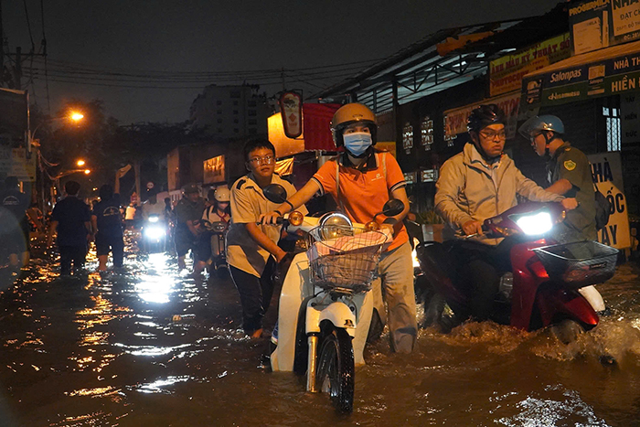 TP.HCM: Triều cường dâng cao, người dân vất vả lội nước về nhà